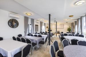 a room with tables and chairs and a clock on the wall at Aduke's Residence Abuja in Abuja