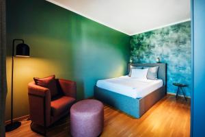 a bedroom with a bed and a chair at Brera Serviced Apartments Ulm in Ulm