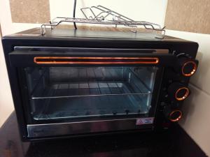 a toaster oven with a rack on top of it at SITER Holidays Villa in Kovalam