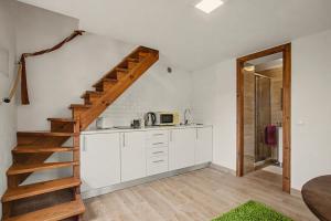 a kitchen with white cabinets and a wooden staircase at Quinta Vale Formoso in Venda da Costa