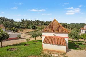 a small building with a tile roof on a field at Quinta Vale Formoso in Venda da Costa