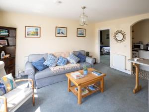 a living room with a couch and a table at Idyllic, Luxurious Seaside Flat for 4. in Borth