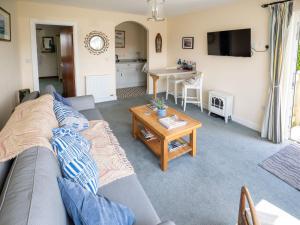 a living room with a couch and a table at Idyllic, Luxurious Seaside Flat for 4. in Borth