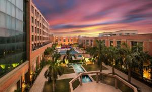 an overhead view of a building with a pool and palm trees at NIRVANA Luxury Hotel l Ludhiana in Ludhiana
