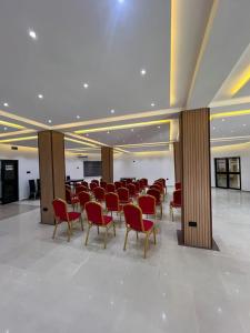 a large room with red chairs and tables in it at Rivona Hotels & Suites in Uyo