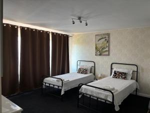 a room with two beds and a window with curtains at Pensiunea Casa Copou in Iaşi