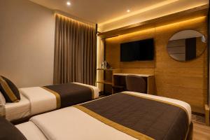 a hotel room with two beds and a television at Hotel Bricks, Karol Bagh, New Delhi in New Delhi