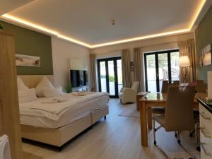 a hotel room with a bed and a desk and a room at Strand FeWo Rügen Baltic Sea in Binz