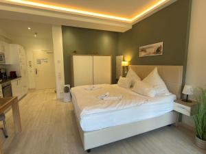 a bedroom with a large white bed in a room at Strand FeWo Rügen Baltic Sea in Binz