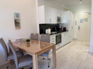 a kitchen with a wooden table and chairs in a room at Strand FeWo Rügen Baltic Sea in Binz