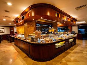 a restaurant with a bar with food on it at Swissotel Quito in Quito