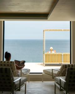 a woman sitting in chairs looking out at the ocean at THE NICI Newquay in Newquay
