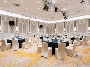 a large room with tables and chairs in it at Mövenpick Myth Hotel Patong Phuket in Patong Beach +170 photos