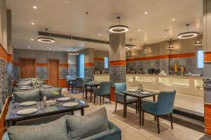 a restaurant with tables and chairs and a kitchen at Perfectstayz Premium Mahadev Regency in Katra