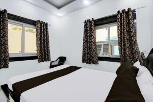 a bedroom with two beds and a window at Hotel O Magadh Guest House in Gaya