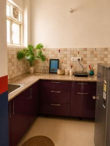 a kitchen with brown cabinets and a counter top at 5 Mins from Prem Mandir 1 BHK Apartment in Vrindāvan