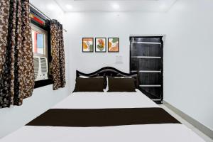 a bedroom with a large bed with a black headboard at Hotel O Magadh Guest House in Gaya