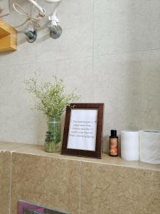 a framed picture sitting on a counter with toilet paper at 5 Mins from Prem Mandir 1 BHK Apartment in Vrindāvan +11 photos