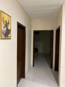 a hallway with two doors and a painting on the wall at City Haven Faisalabad in Faisalabad