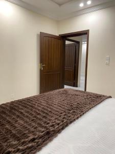 a bedroom with a large bed with a brown blanket at City Haven Faisalabad in Faisalabad