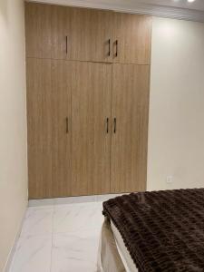 a bedroom with wooden cabinets and a bed at City Haven Faisalabad in Faisalabad