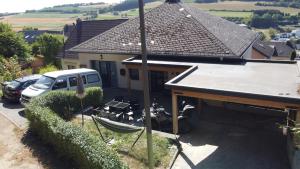 a house with a boat parked in a driveway at Weitblick am Rammenfeld in Schönecken