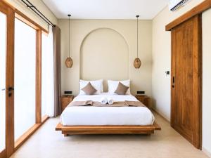 a bedroom with a large bed with white sheets at Oasis Dune Villas Lombok in Kuta Lombok +47 photos