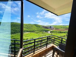 a view from the balcony of a house with a chair at Cloud Valley Inn in Cherrapunji