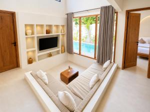 a living room with a couch and a tv at Oasis Dune Villas Lombok in Kuta Lombok