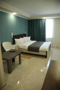 a bedroom with a bed and a table and a window at Vell Grey Hotel in Martuni