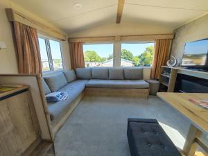 a living room with a couch and some windows at Sunnycott Caravan Park in Cowes