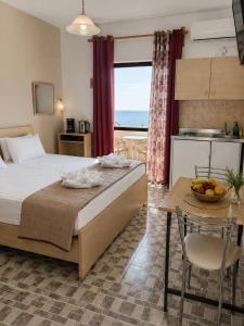 a bedroom with a bed and a table with a bowl of fruit on it at Soula Apartments & Studios in Palaiochora