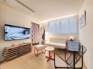 a living room with a couch and a flat screen tv at 호텔느릿 in Seoul