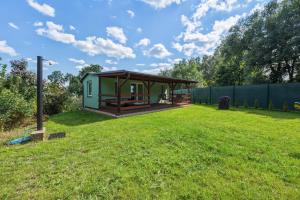 a green cabin in a field with a grass yard at NATALiHAUS in Děčín