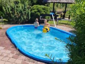 a couple of people in a swimming pool at Pensjonacik Ewa in Darłowo