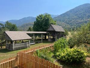 a garden with a wooden fence and a gazebo at Bohinj Nook Apartment in Bohinj