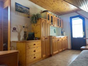 a kitchen with wooden cabinets and a dresser at Bohinj Nook Apartment in Bohinj +32 photos