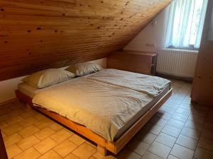 a bed in a room with a wooden ceiling at Bohinj Nook Apartment in Bohinj