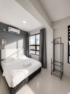 a bedroom with a large white bed and a window at Hotel Casaria in Paka