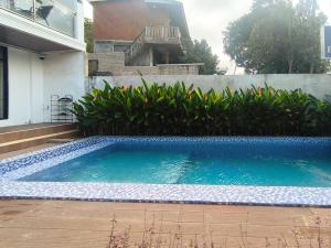 a swimming pool in front of a house at The Lavana Hotel Florida Kuta Mandalika in Kuta Lombok