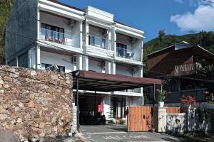 a large white building with a stone wall at The Lavana Hotel Florida Kuta Mandalika in Kuta Lombok