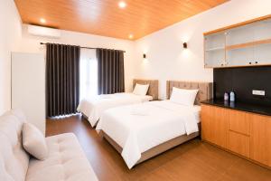 a hotel room with two beds and a couch at The Lavana Hotel Florida Kuta Mandalika in Kuta Lombok +29 photos