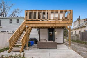 a wooden deck with a couch under it at Modern 1 Bdrm with Laundry, BBQ, Deck in Welland