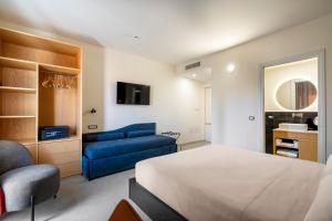 a bedroom with a bed and a blue couch at Istedda Boutique Hotel in Villasimius