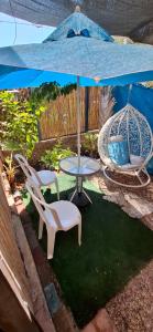 a patio with a table and chairs and an umbrella at AN edom suite in Eilat
