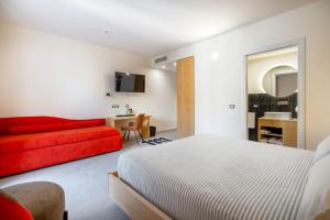 a bedroom with a bed and a red couch at Istedda Boutique Hotel in Villasimius
