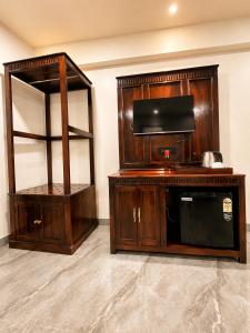 a room with wooden furniture and a microwave and a shelf at Grand Valley - A Boutique Resort in Mount Abu in Mount Ābu