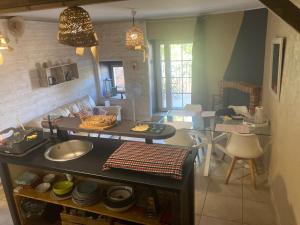 a kitchen and living room with a sink and a table at La petite maison in Lagorce