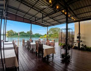 a restaurant with tables and chairs and a view of the water at Paradise resort, Don Det river view in Don Det