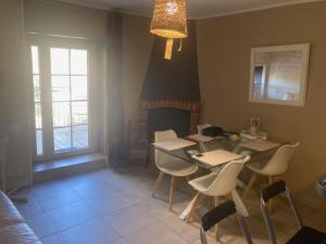 a dining room with a table and chairs and a fireplace at La petite maison in Lagorce